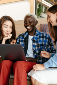 Three Happy Women Looking at a Laptop Computer on a Couch